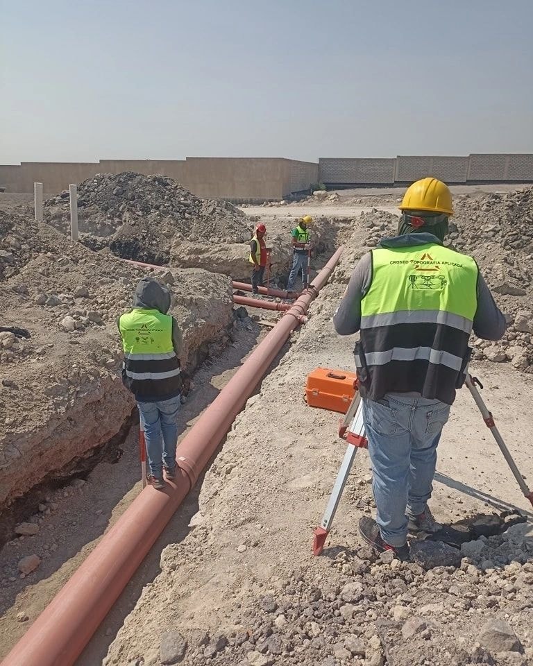 Trabajadores en obra inspeccionando tubería